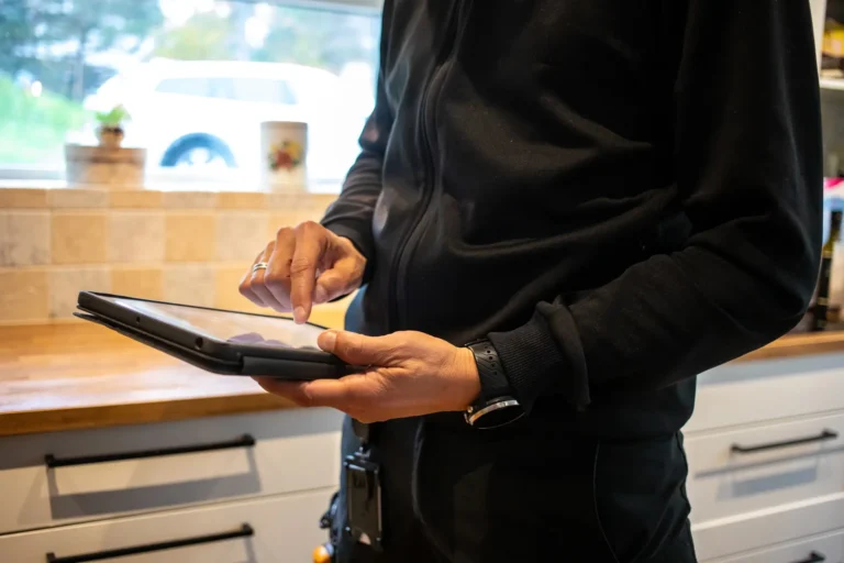 Avflyttningsbesiktning av man i kök med ipad